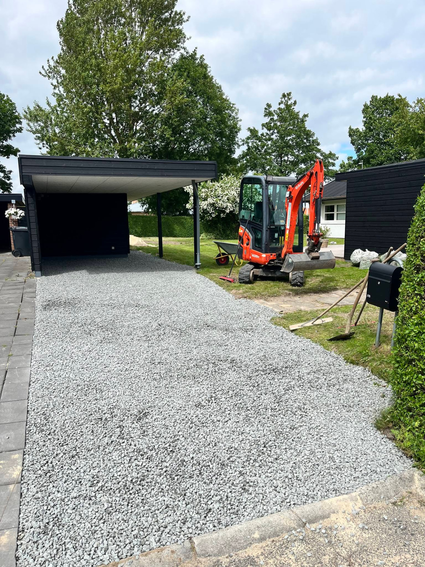 Færdig grusindkørsel ved sort carport